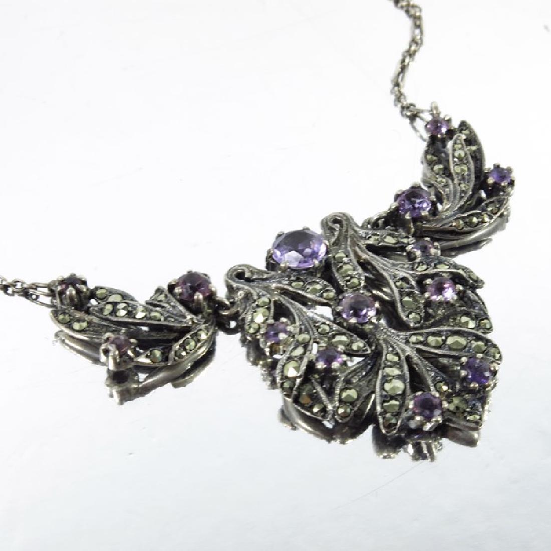 Bernard Instone, an Art Deco silver, marcasite and: Bernard Instone, an Art Deco silver, marcasite and amethyst necklace, circa 1925, articulated, stylised open foliate design with graduated stones, stamped marks, pendant 3.5cm long, 39cm long