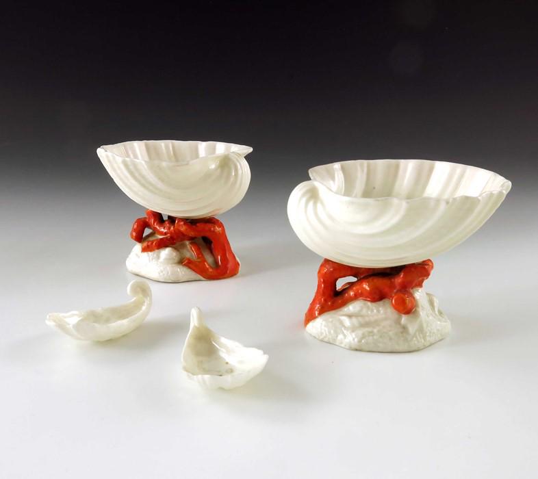 A pair of Belleek first period Clam Shell salt cellars: A pair of Belleek first period Clam Shell salt cellars and spoons, realistically modelled on orange coral bases, the spoons also in the form of shells, impressed marks, 8cm diameter