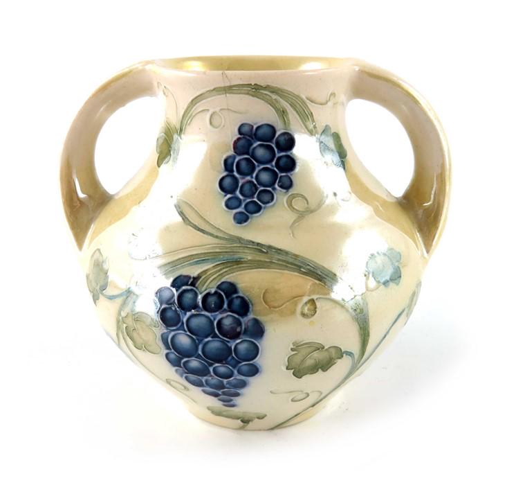 William Moorcroft for Liberty and Co., a small lustre: William Moorcroft for Liberty and Co., a small lustre Grapes vase, circa 1909, twin handled amphora form, underglaze green signature, 8cm high