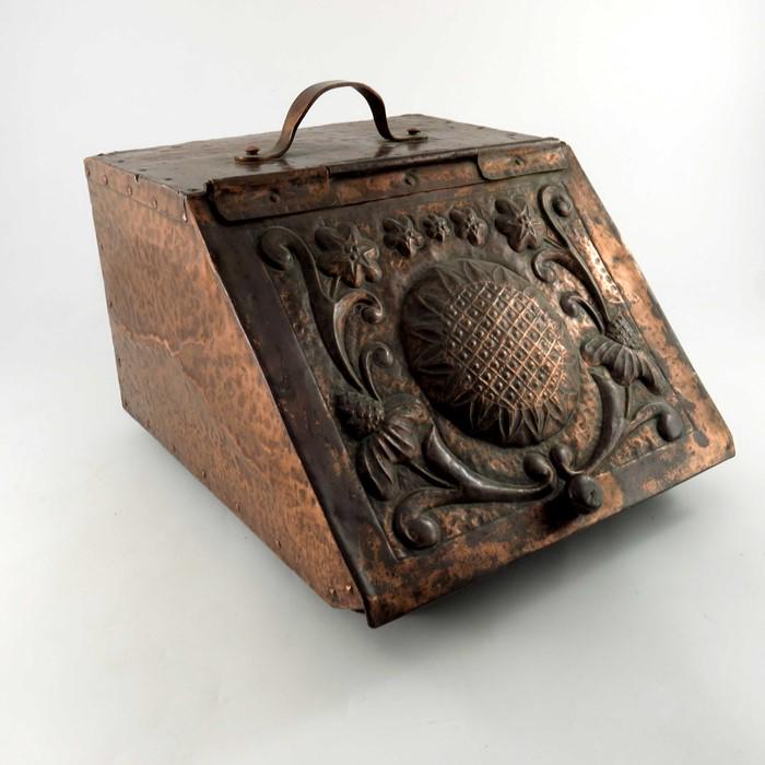 John Pearson (attributed), an Arts and Crafts copper: John Pearson (attributed), an Arts and Crafts copper coal scuttle, the angled lid repousse decorated with sunflower and foliate scrolls, 28cm high