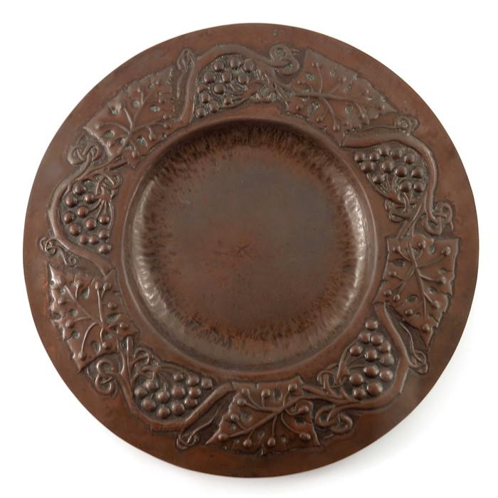 John Pearson (attributed), an Arts and Crafts copper: John Pearson (attributed), an Arts and Crafts copper broad rimmed dish, repousse decorated with fruiting vines to the border, 36cm diameter