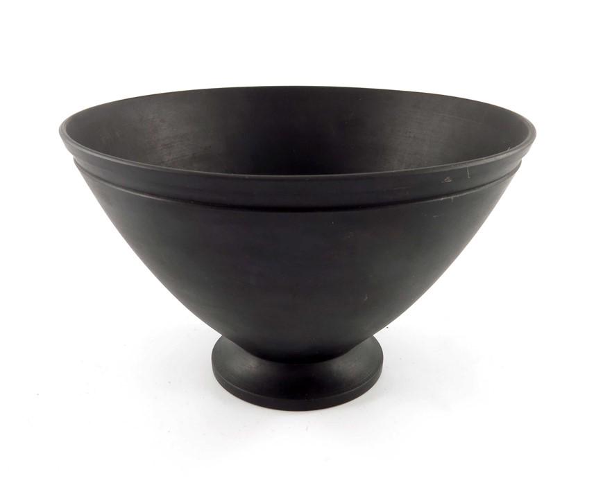 Keith Murray for Wedgwood, a black basalt bowl, circa: Keith Murray for Wedgwood, a black basalt bowl, circa 1933, footed conical form with incised band to the rim, impressed marks and printed facsimile, 10.5cm high