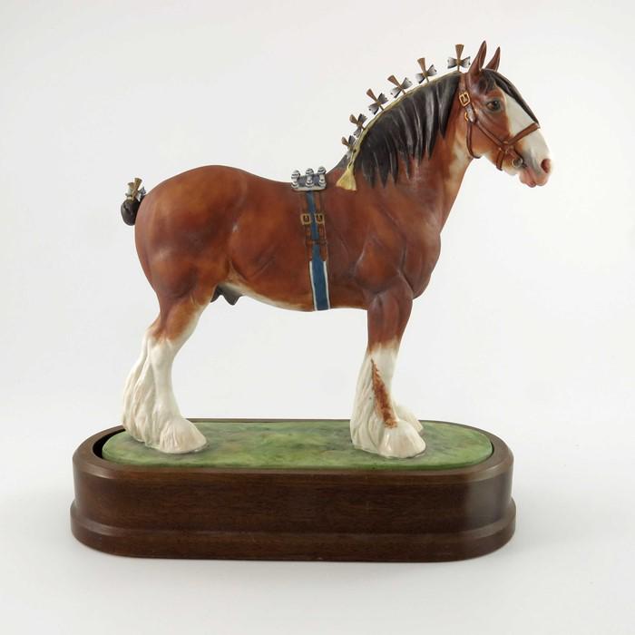 Doris Lindner for Royal Worcester, a porcelain model of: Doris Lindner for Royal Worcester, a porcelain model of a Clydesdale Stallion, 1976, raised on oval ceramic base surmounted by a wood plinth, number 285, black printed factory marks to base, 28cm high