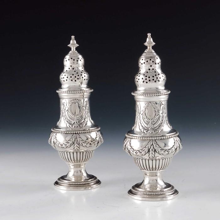 A pair of Victorian silver casters, Charles Stuart: A pair of Victorian silver casters, Charles Stuart Harris, London 1896, George II style footed ogee baluster form, embossed with gadroons, reeding and beaded borders, 15cm high, 7.25ozt (2)
