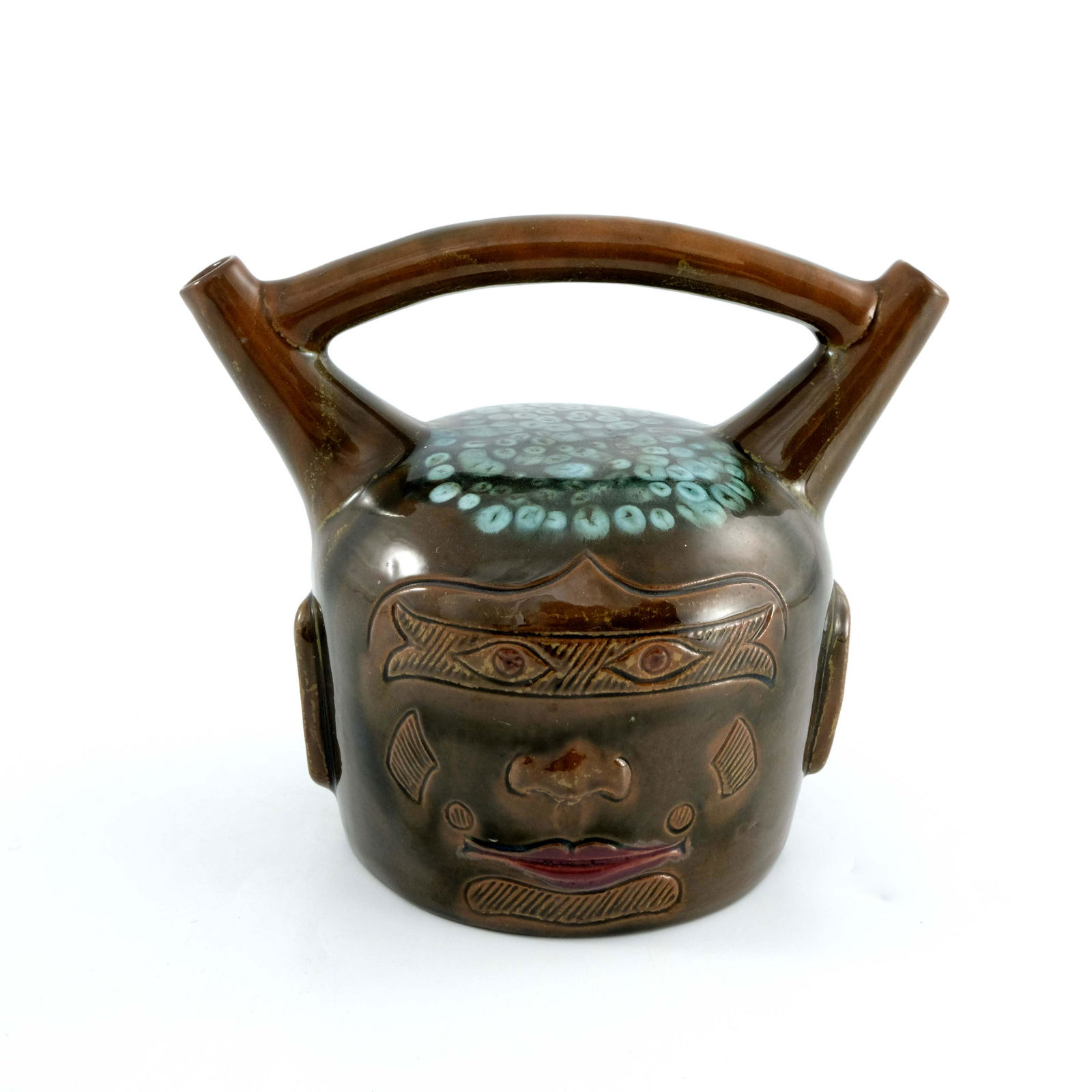 Christopher Dresser for Linthorpe, an art pottery: Christopher Dresser for Linthorpe, an art pottery Peruvian vessel, circa 1880, modelled after a pre Columbian face jug, double spout and bridge form, incised and relief moulded with features, brown gl