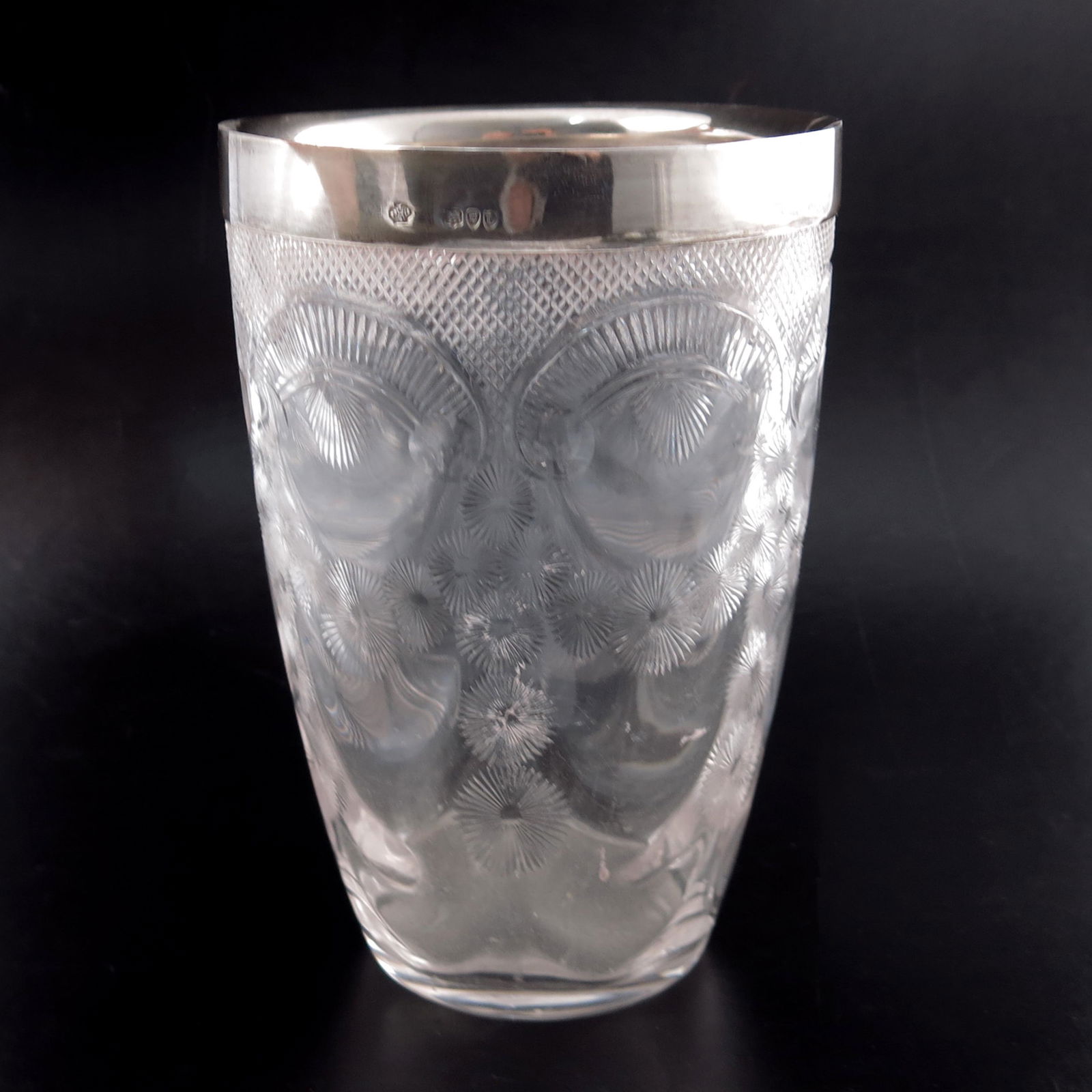 A Victorian silver mounted cut glass ice bucket,: A Victorian silver mounted cut glass ice bucket, probably Thomas Webb for William Hutton, London 1895, the optic wave moulded body decorated with floral festoons and gadrooned C scrolls, below hobnail