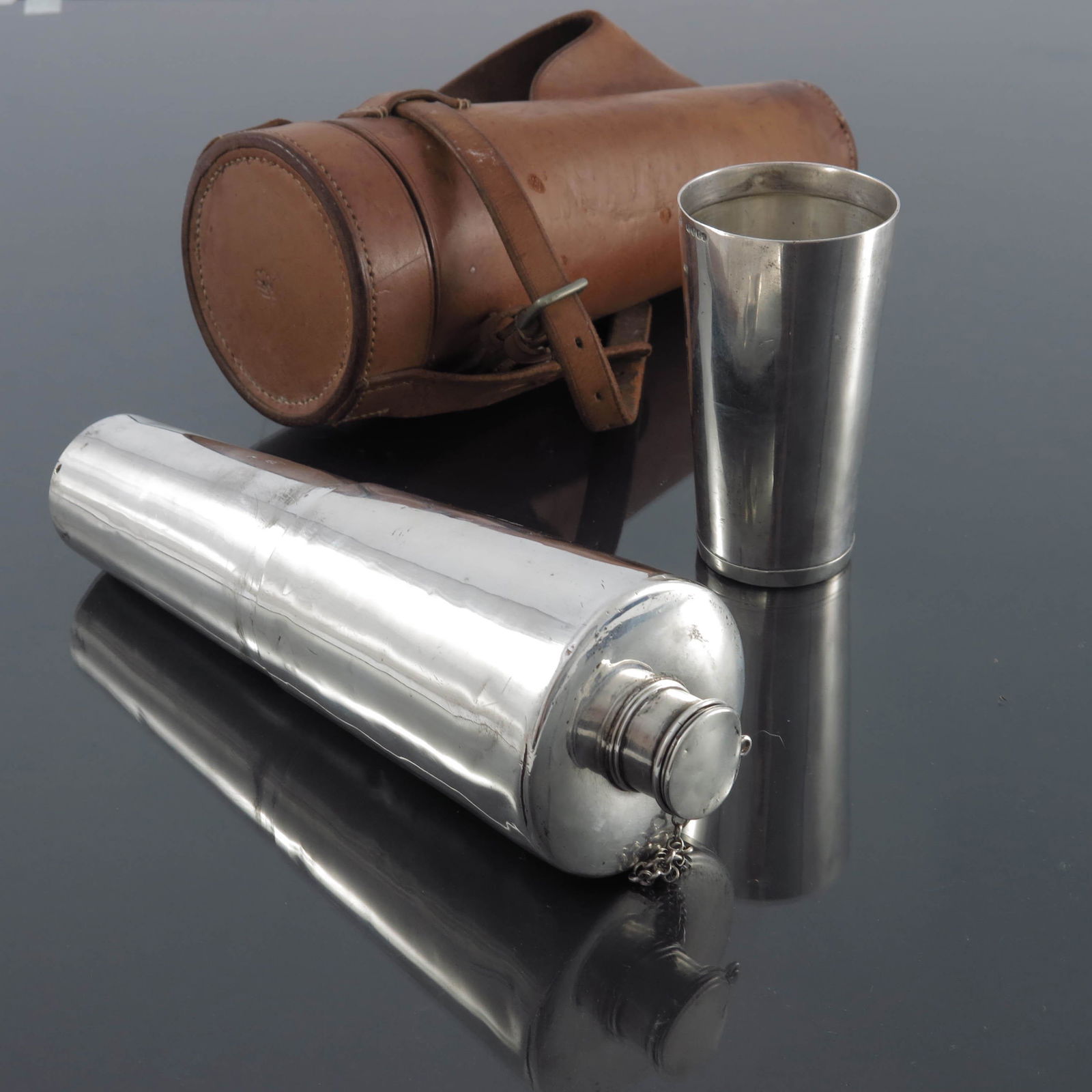 A Victorian silver hunting flask in leat: A Victorian silver hunting flask in leather case, Thomas Johnson, London 1856, conical form with removable beaker, screw cap, in fitted stitched leather holder, retailer IW and FB Thomas, 21cm high, 1