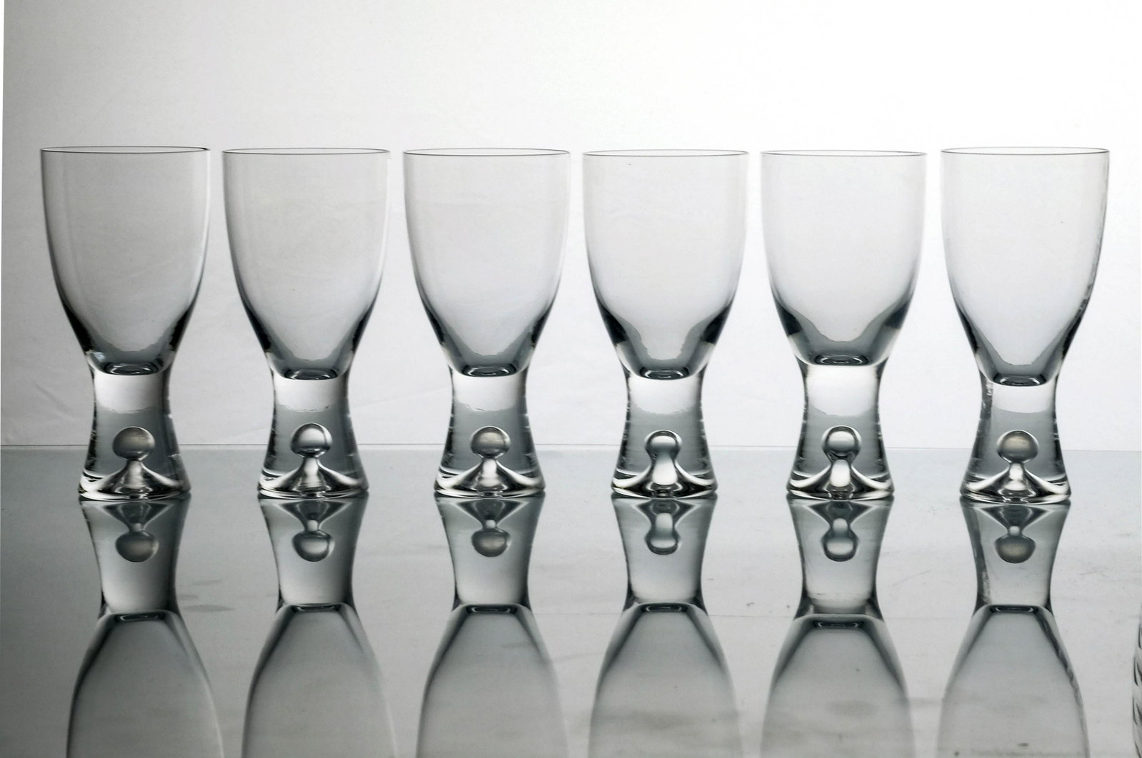 Tapio Wirkkala for Iittala, a set of six: Tapio Wirkkala for Iittala, a set of six Tapio wine glasses, designed circa 1952, each with open air bubble inclusion to the conical stem, 13cm high (6)