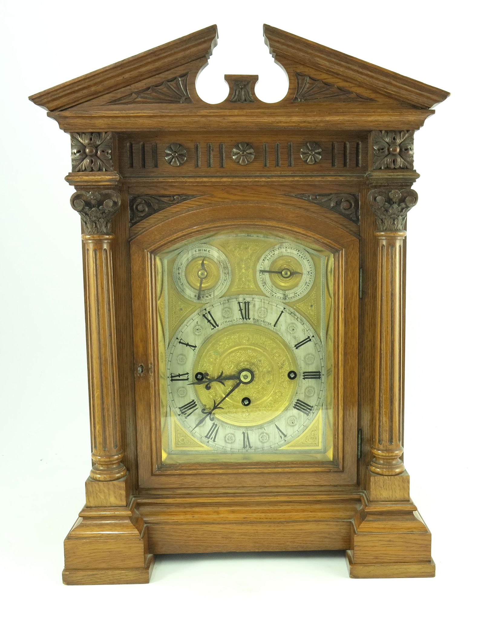 John Hall & Co, Manchester, a late Victo: John Hall & Co, Manchester, a late Victorian light oak bracket clock, circa 1890, the case of Baroque design with broken pediment, arched bright cut engraved brass dial with silvered subsidiary slow/f