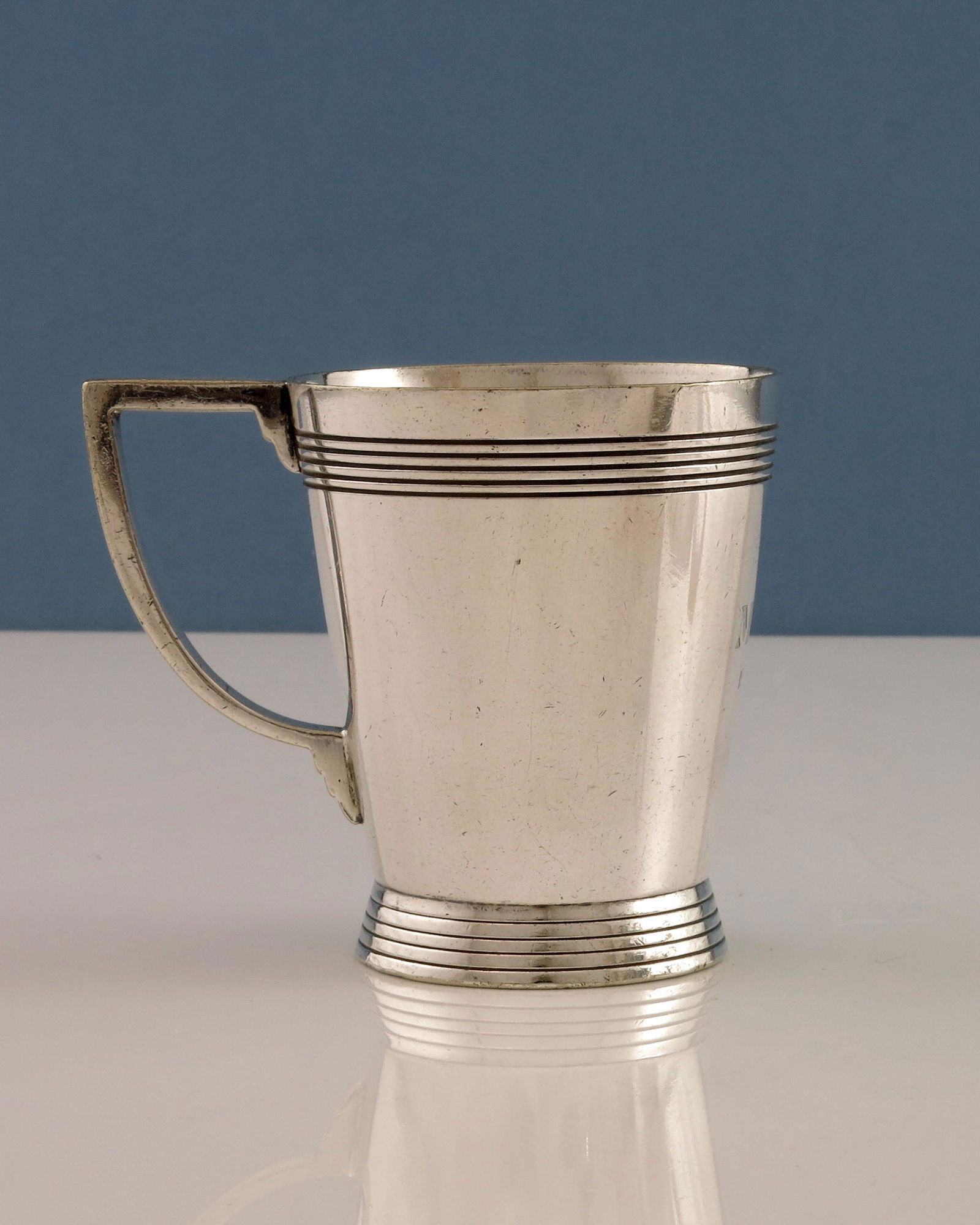 Keith Murray for Mappin and Webb, an Art: Keith Murray for Mappin and Webb, an Art Deco silver plated mug, circa 1934, footed conical form with concentric banding, angled and stepped handle, W27689, Prince's Plate, 8.5cm high