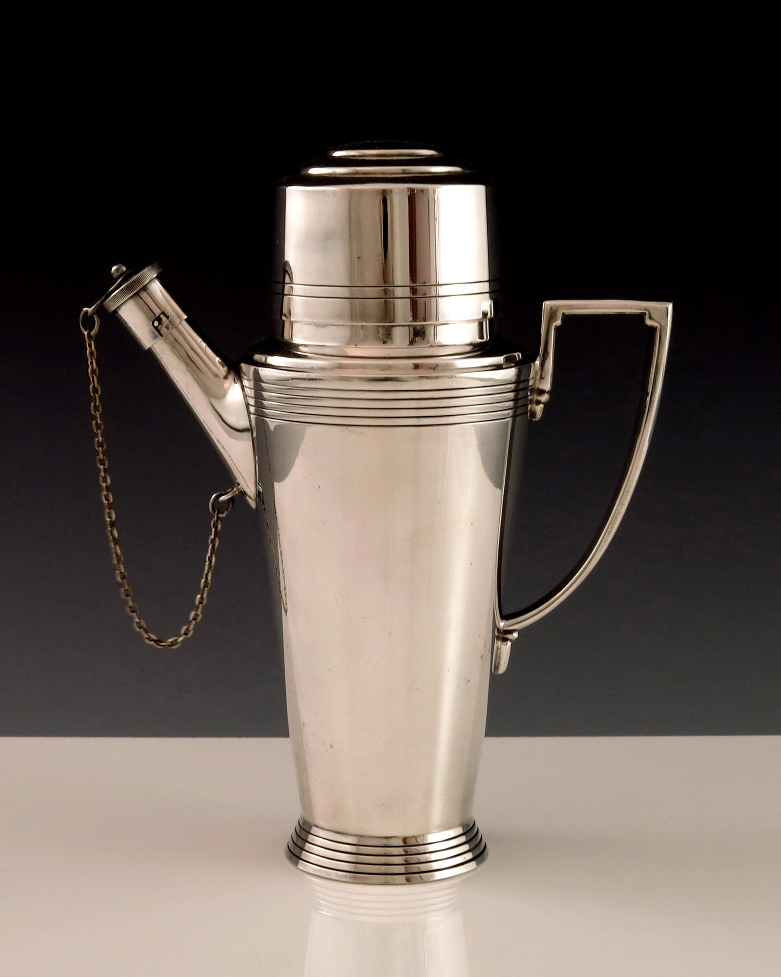 Keith Murray for Mappin and Webb, an Art: Keith Murray for Mappin and Webb, an Art Deco silver plated cocktail shaker, circa 1933, shouldered conical form with bands of concentric rings, angled and stepped handle, the pouring spout with cork