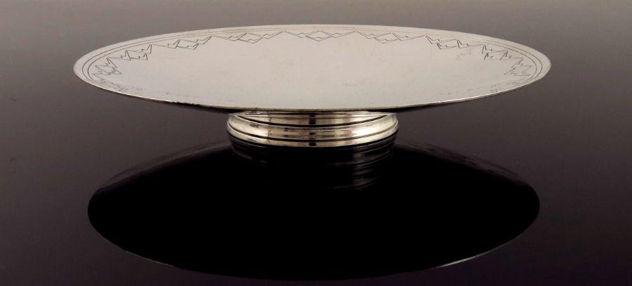 Keith Murray for Mappin and Webb, an Art: Keith Murray for Mappin and Webb, an Art Deco silver plated comport, circa 1934, circular shallow dished form, engraved with a band of concentric rings and geometric batwing design, concentric ringed