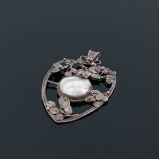 An Arts and Crafts silver and mother of: An Arts and Crafts silver and mother of pearl pendant, in the style of John Paul Cooper, heart shaped open ropetwist frame with applied leaves and berries, around a central roundel, 6.5cm long, 10.6g