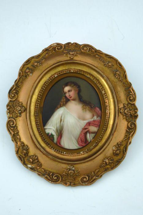 A late 19th Century oval KPM convex plaq: A late 19th Century oval KPM convex plaque, painted with a portrait of a young lady, half length wearing classical drapery, impressed maker's mark, 12 by 10cm, gilt frame