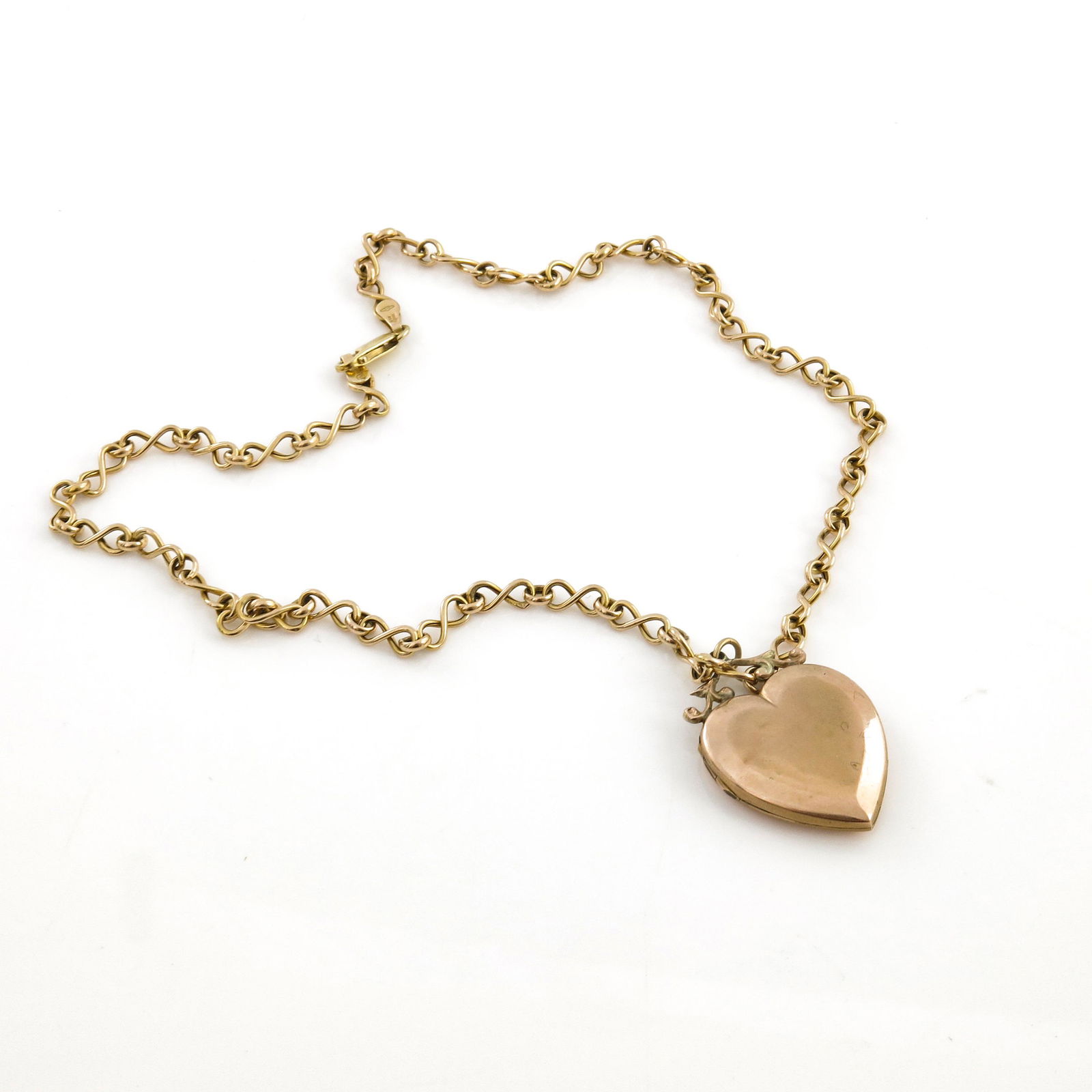 A 9ct gold heart shaped locket, on a fin: A 9ct gold heart shaped locket, on a fine kerb-link chain