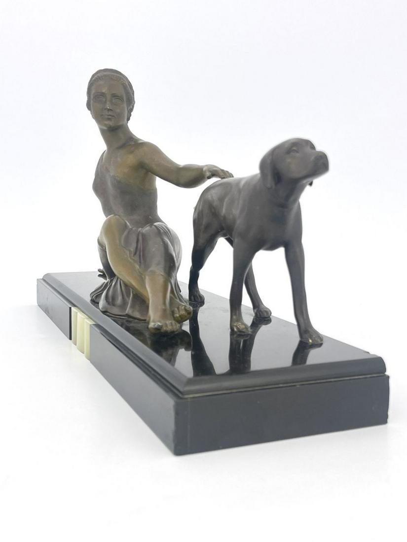Ugo Cipriani, an Art Deco patinated art: Ugo Cipriani, an Art Deco patinated art metal figure group, circa 1925, modelled as a woman and a dog, on marble and onyx base, apparently unsigned, 45.5cm long