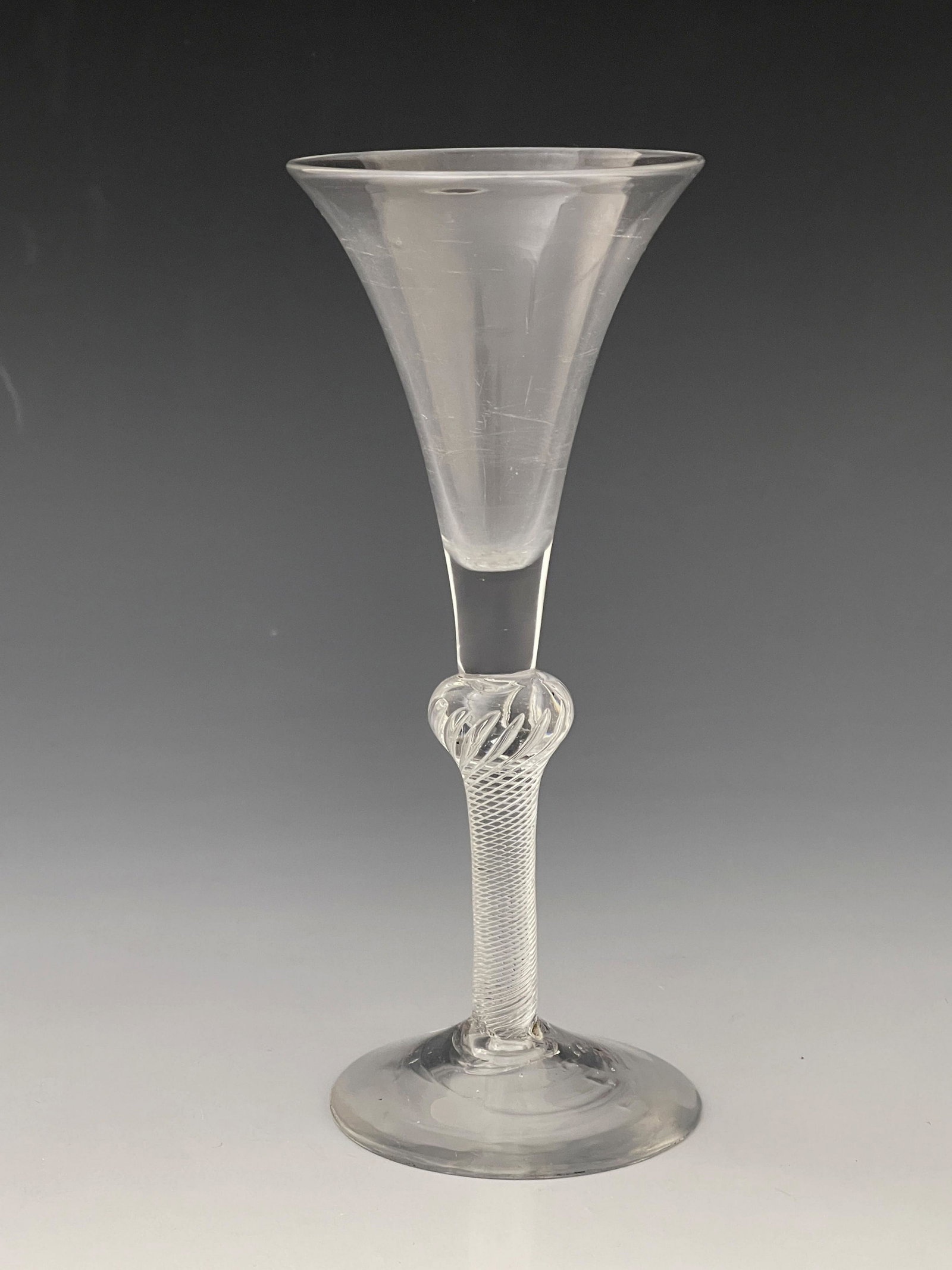 A composite stem wine glass, circa 1750,: A composite stem wine glass, circa 1750, the trumpet bowl on inverse baluster multi spiral air twist stem, conical foot, 18cm high, foot 7.1cm diameter, rim 7.4cm diameter