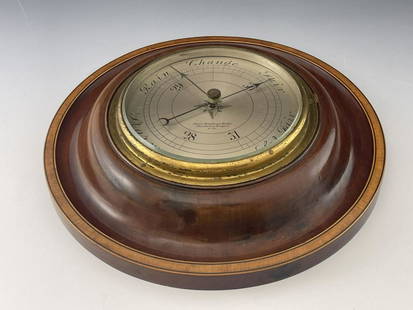 Thomas Armstrong & Brother, Manchester a: Thomas Armstrong & Brother, Manchester and Liverpool, a late 19th/early 20th Century Aneroid barometer, 15cm silvered dial, circular mahogany cushion frame crossbanded and strung border, 30cm diameter