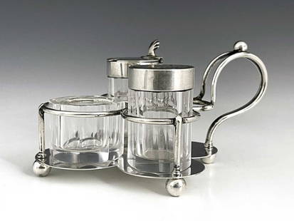 Christopher Dresser for Hukin and Heath,: Christopher Dresser for Hukin and Heath, an Arts and Crafts silver and glass three piece cruet and stand, Birmingham 1884, the quatrefoil platform with wire loop and rod cradle containing slice cut