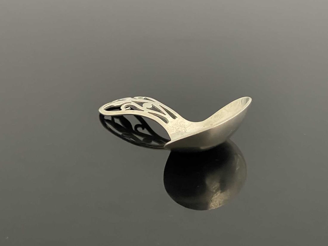 Bernard Instone, an Arts and Crafts silv: Bernard Instone, an Arts and Crafts silver caddy spoon, Langstone Silver Works, Birmingham 1920, fret pierced tulip motif to the handle, 7cm long, 0.65ozt