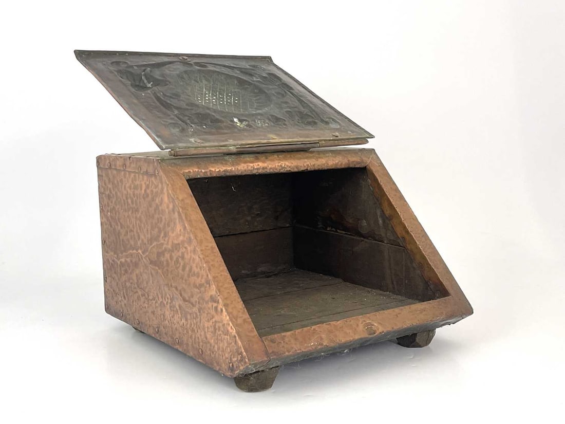 John Pearson (attributed) an Arts and Cr: John Pearson (attributed) an Arts and Crafts copper clad coal scuttle, the hinged lid repousse embossed with sunflower flanked by foliate floral fronds, 34cm wide, 30cm high