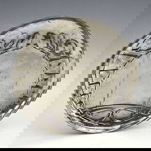Archibald Knox for Liberty and Co., a Tu: Archibald Knox for Liberty and Co., a Tudric Arts and Crafts pewter plate, model 0231, circular form, cast in relief with knotted leafy tendrils terminating in buds, 14cm diameter