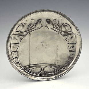 Archibald Knox for Liberty and Co., a Tu: Archibald Knox for Liberty and Co., a Tudric Arts and Crafts pewter plate, model 0231, circular form, cast in relief with knotted leafy tendrils terminating in buds, 14cm diameter