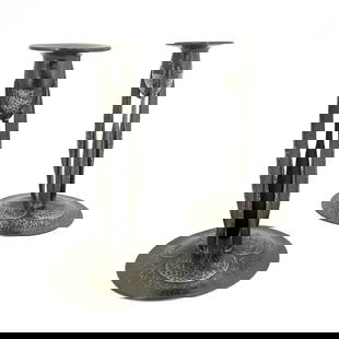 Archibald Knox for Liberty and Co., a pa: Archibald Knox for Liberty and Co., a pair of Tudric Arts and Crafts pewter candlesticks, model 0223, planished and formed of three bladed buttress supports, on domed foliate bases, 23.5cm high