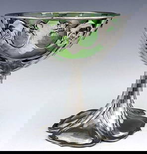 Archibald Knox for Liberty and Co., a Tu: Archibald Knox for Liberty and Co., a Tudric Arts and Crafts pewter and green glass pedestal bowl, model 0955, the reticulated knotted tendril and berry bowl on a four ogee petal moulded sweeping foot