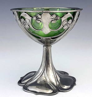 Archibald Knox for Liberty and Co., a Tu: Archibald Knox for Liberty and Co., a Tudric Arts and Crafts pewter and green glass pedestal bowl, model 0955, the reticulated knotted tendril and berry bowl on a four ogee petal moulded sweeping