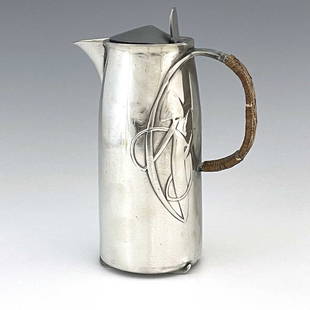 Archibald Knox for Liberty and Co., a Tu: Archibald Knox for Liberty and Co., a Tudric Arts and Crafts pewter hot water jug, model 0231, tapered cylindrical form, cast with knotted tendril motifs and looped rattan handle, on skate feet,