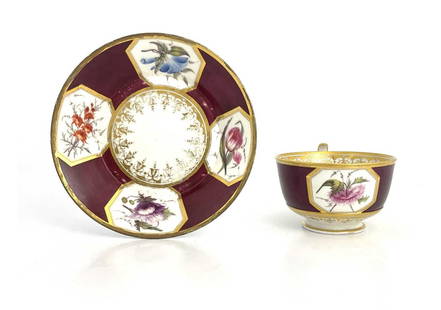 A Barr, Flight and Barr Royal Worcester: A Barr, Flight and Barr Royal Worcester floral specimen tea cup and saucer, maroon ground with octagonal panels of floral specimens, gilt bordered and rimmed, impressed and printed marks, 14.5cm diame
