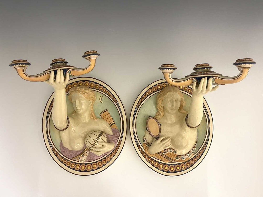 A pair of Minton relief moulded wall sco: A pair of Minton relief moulded wall sconces, circa 1860s, modelled a allegorical figures of Truth and Invention, depicting semi nude Classical women emerging crom concave oval roundels, with one arm 