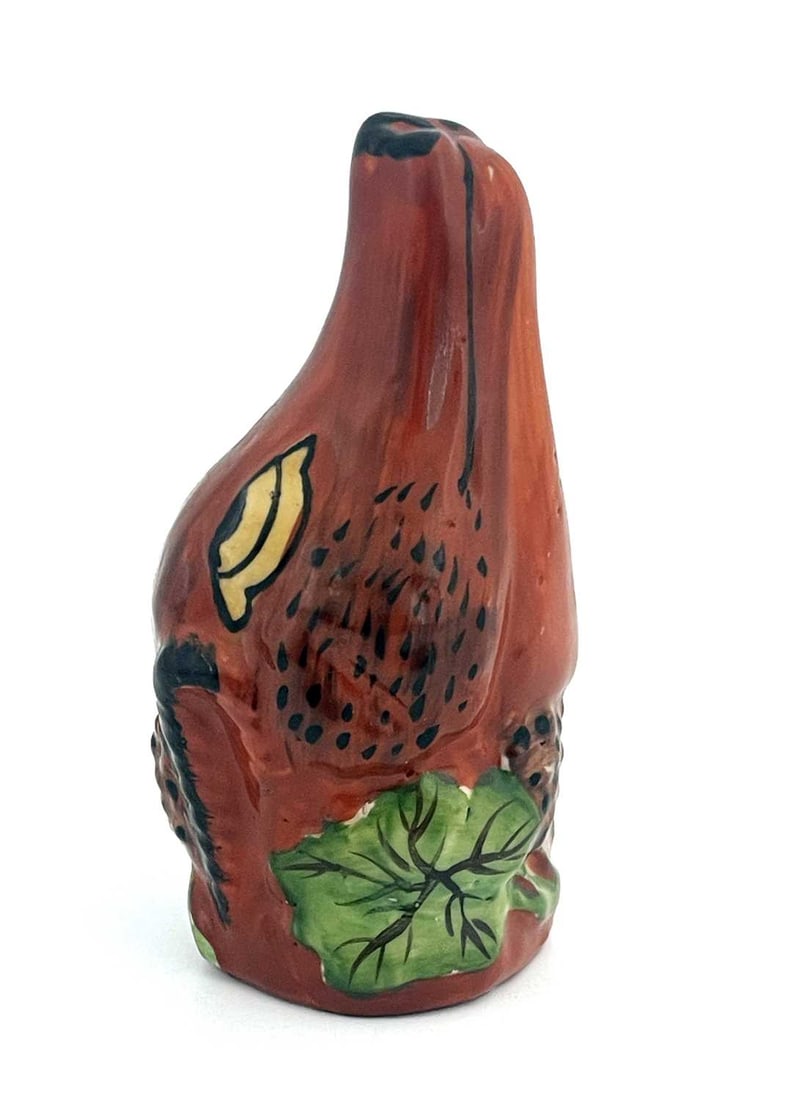 A 19th century Staffordshire porcelain f: A 19th century Staffordshire porcelain fox head stirrup cup, circa 1870, modelled in relief and painted, with fruiting grape vines, 12cm long Provenance: Goodfellow Collection