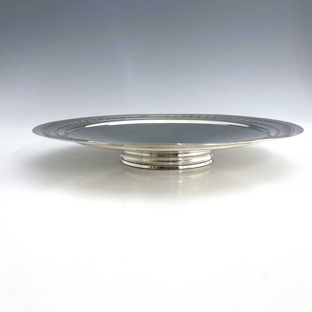 Keith Murray for Mappin and Webb, an Art: Keith Murray for Mappin and Webb, an Art Deco silver plated comport, circa 1933, circular dished form with stepped rim, engraved with a geometric overlapping chevron design, concentric ringed conical