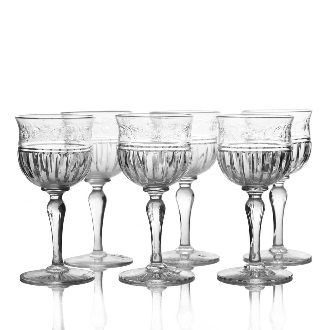 Thomas Webb, a set of six Edwardian inta: Thomas Webb, a set of six Edwardian intaglio rock crystal cut wine or port glasses, circa 1910, the bell shaped bowls with bands of foliate scrolls and floral motifs above vertical mitre cuts, on inve