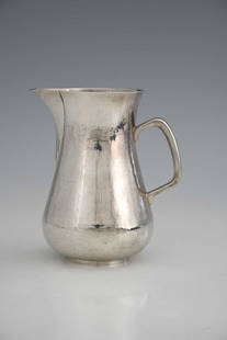 Robert Welch. An Elizabeth II Arts & Crafts style silver jug, of bellied cylindrical form with: Robert Welch. An Elizabeth II Arts & Crafts style silver jug, of bellied cylindrical form with planished exterior, the angular C scroll handle with sparrow beak style spout, Robert Welch, London 1996,