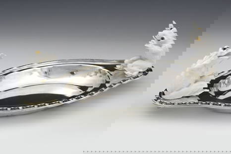 Christopher Dresser for Hukin and Heath,: Christopher Dresser for Hukin and Heath, an Aesthetic Movement silver plate and ceramic dish, circa 1880, oval ogee form with cast scallop shell and wave border, the handles mounted with white ceramic