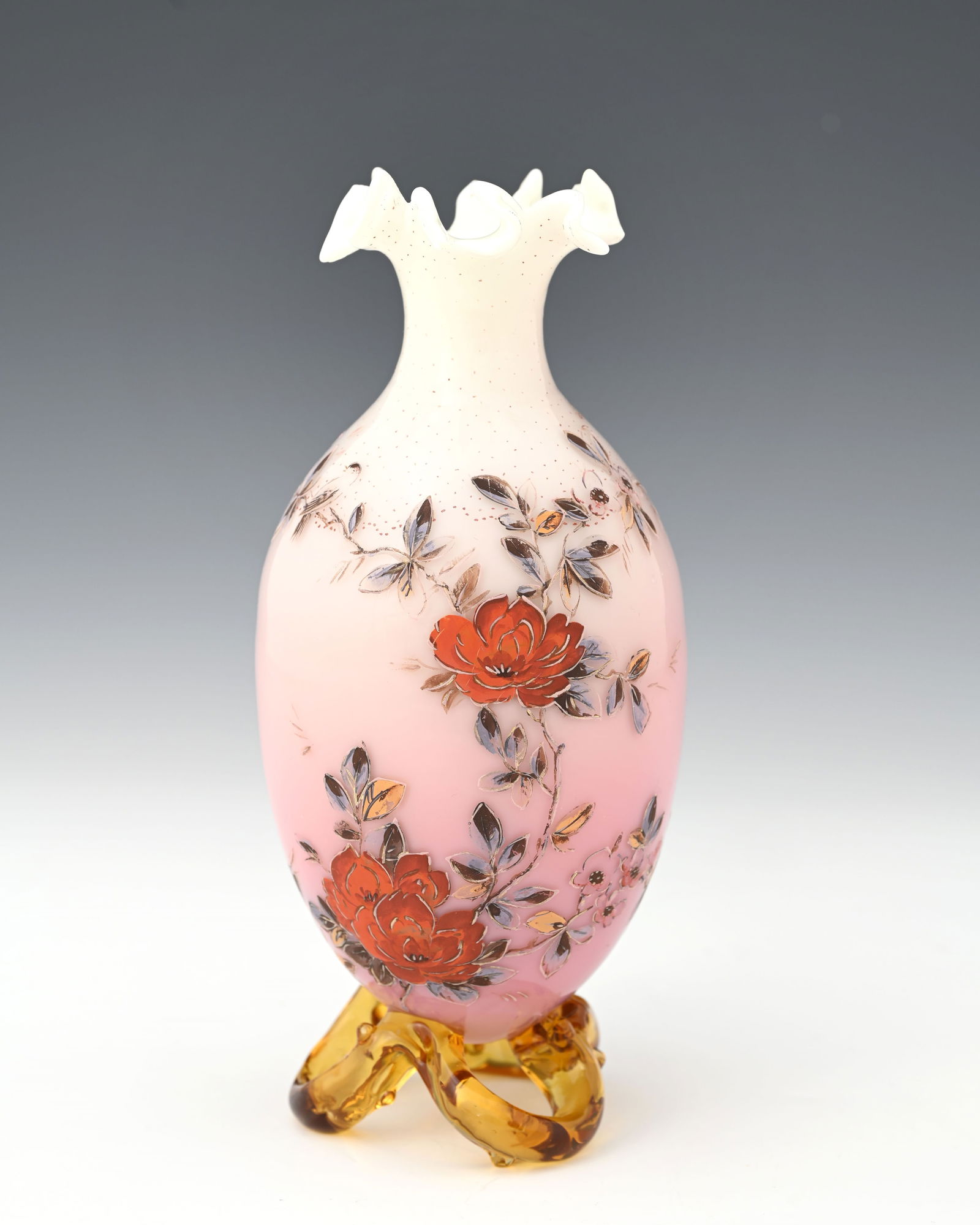 A Stourbridge pink blushed opaque and am: A Stourbridge pink blushed opaque and amber glass vase, possibly Thomas Webb, enamelled with flowers, with cut and crimped rim, on a thorny open trefoil branch foot, 21cm high