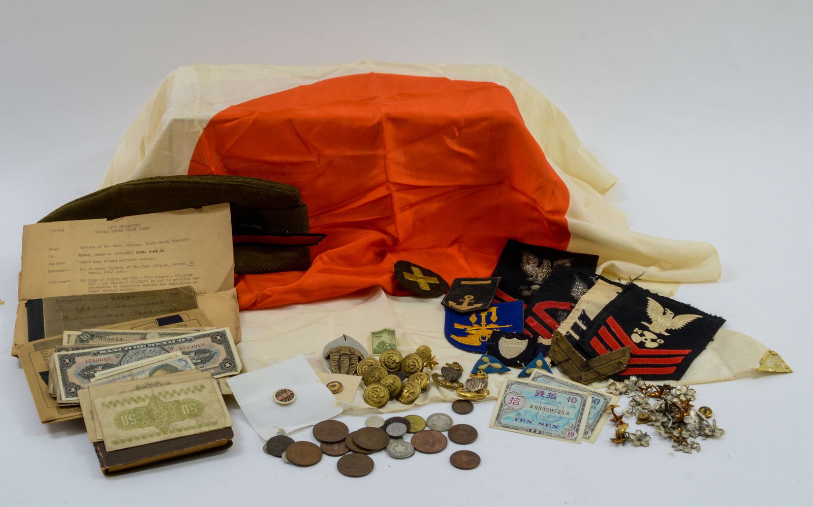 Military collectibles group: Estate-Fresh Group of WWII era Military items including a 38" x 26" silk Japanese Flag, paper money from the South Pacific Theater, Navy Documents, A Serviceman's Journal, Patches, Pins, US and Japane