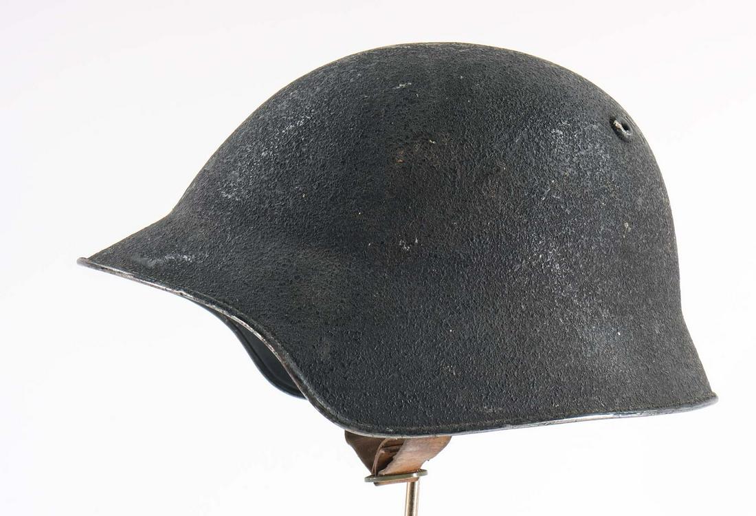 Switzerland M18/43 steel helmet: Swiss M18/43 steel helmet with leather liner and chin strap. The steel helmet has light scuffs and scratches throughout. The interior has a touch of spotting mold from long storage. The leather head l
