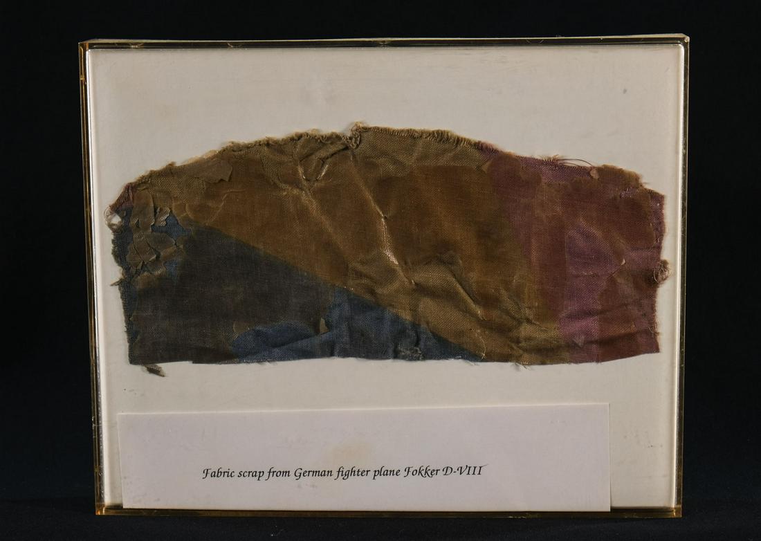 Fabric Scrap from German Fighter Plane: Canvas Fabric, painted with a layer of old lacquer or preservative, in a Lucite frame with a printed note: "Fabric Scrap from the German Fighter Plane Fokker D-VIII. No further provenance. 10" x 8" Ke