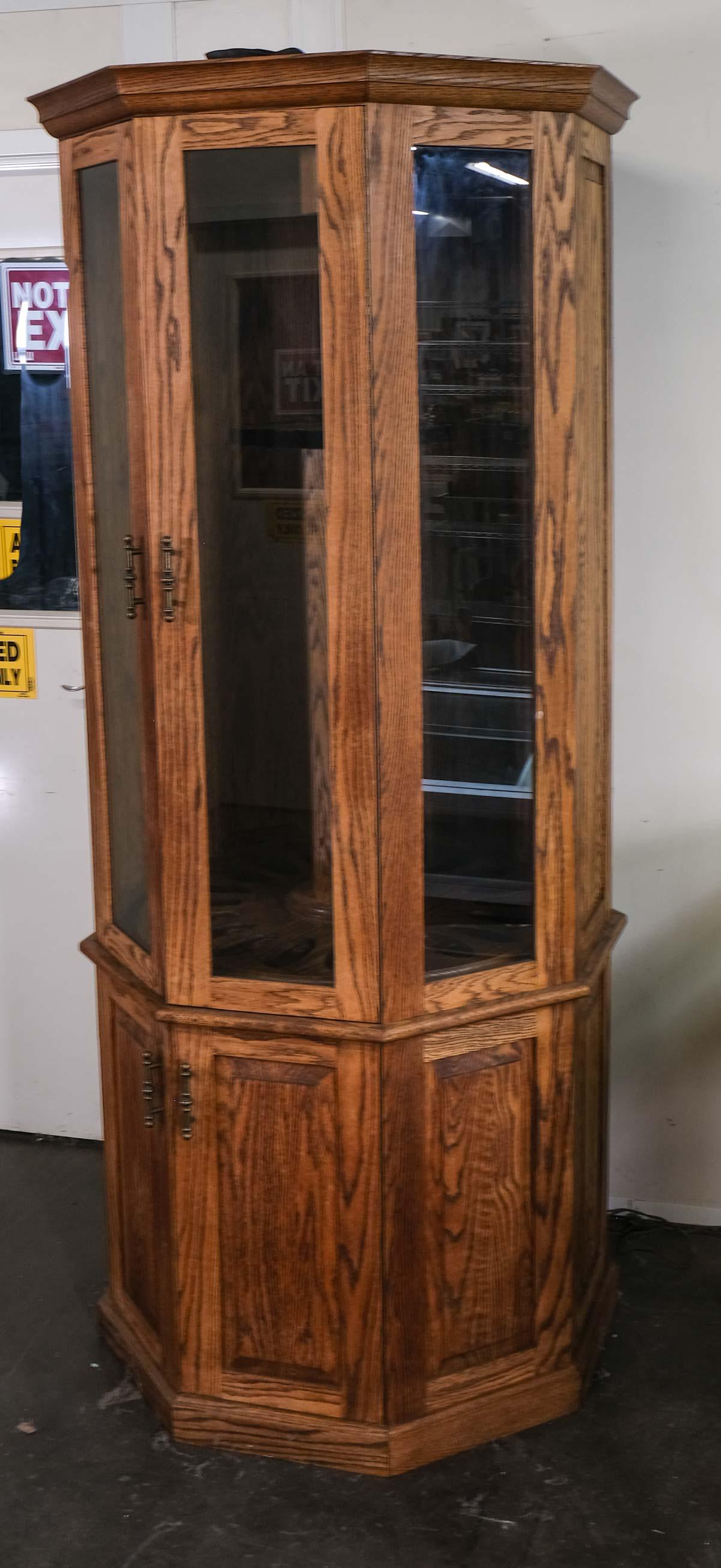 Oak Gun Cabinet Display: Lighted, Solid Oak, Octagonal Gun Cabinet or display case with rotating storage for 20 long guns. Glass Doors, with Four Ball-Bearing draws in bottom section. 20th Century, unmarked. Power cord needs
