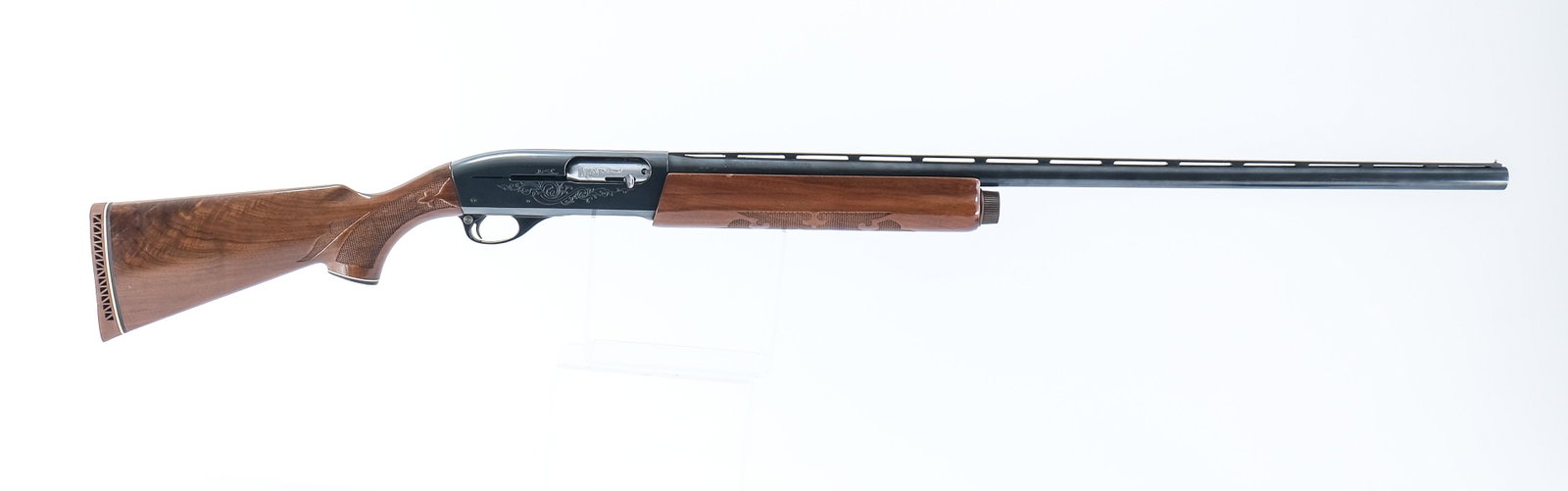 Remington 1100 12ga Shotgun: Remington model 1100 in 12 gauge with a four round internal capacity and a 30" barrel. "Pachmayr" White Line rubber butt pas still supple and free of damage. Stock has light scratches and finish wear.