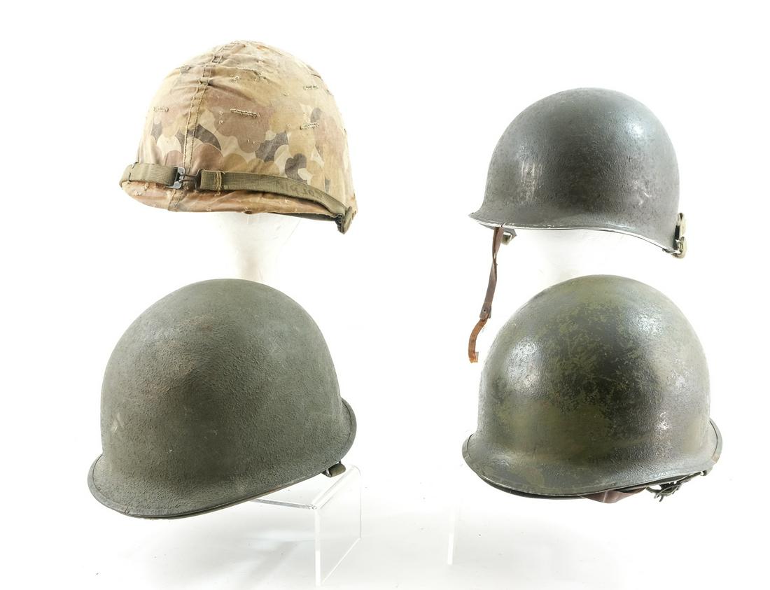 Four US Military M1 Helmets: Mid 20th Century group: WWII and Korean War. All Swivel-bail Models. A textured paint, Front Seam Shell with later dated 1952 liner. This helmet has a unit number hand painted on theback, and a note i