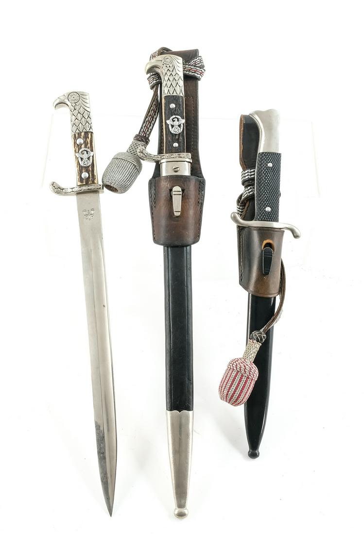 Three German WWII Parade Bayonets: Description Two Germany Third Reich Police Parage Bayonets with Stag, Eagle, and Oak Leaf Hilts. One with matching (serial number modified) scabbard and Carl Eickhorn Solingen marked blade, and the ot
