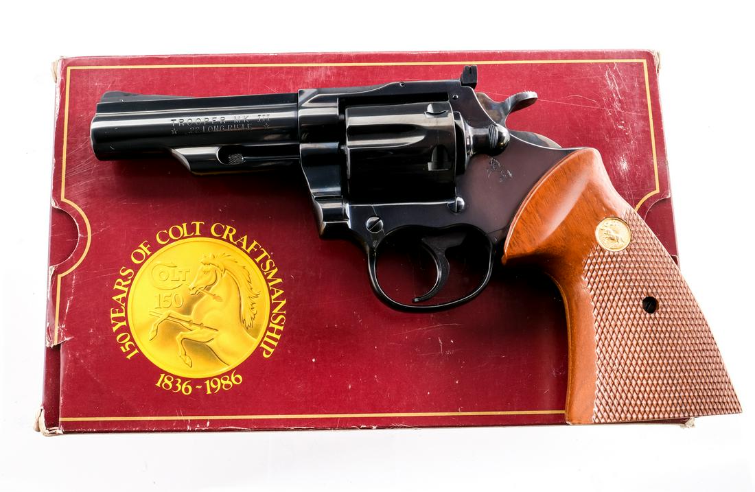 Colt Trooper MK III .22 LR Revolver: Description Colt Trooper MKIII in .22 Long Rifle with a six round capacity and a 4" barrel. Checkered wood grip plates. Blued frame, serrated trigger, cylinder and barrel. Case colored checkered hamme