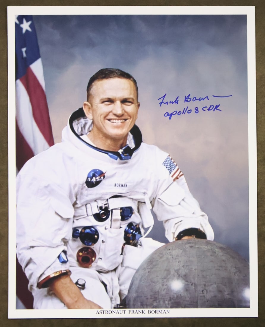Astronaut Frank Borman Signed NASA Lithograph: An NASA lithograph showing an image of Astronaut Frank Borman posing in his white space suit. The lithograph has been boldly hand signed by Frank Borman. This 8" x 10" lithograph is in excellent