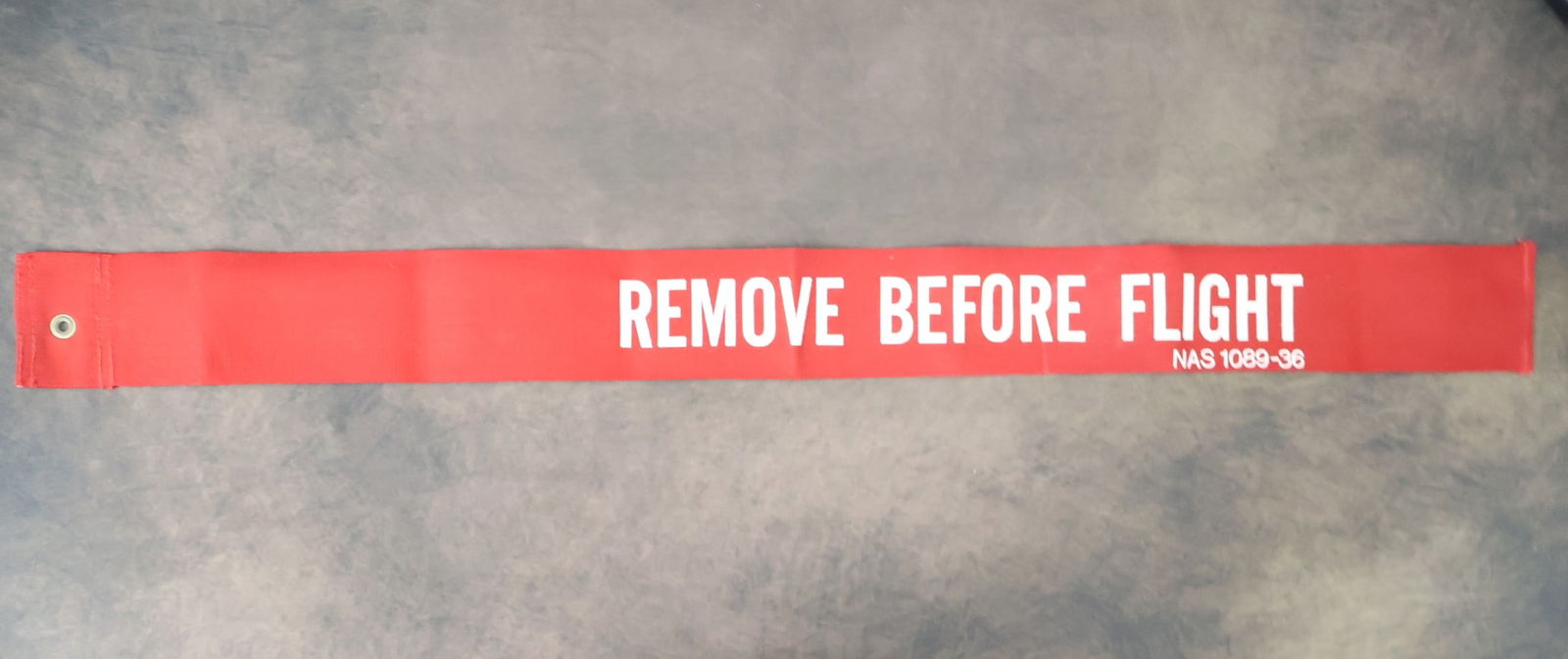 Space Shuttle Nose Gear 'Remove Before Flight' Banner: This authentic "Remove Before Flight" nose gear banner from the Space Shuttle program measures 35" x 3". It is in excellent vintage condition, preserving its vibrant color and integrity. It displays