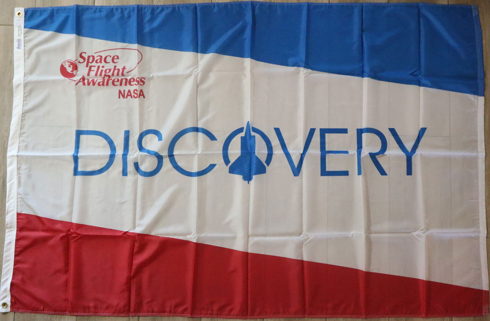 Official NASA Space Shuttle Discovery Flag 4' x 6': An original NASA Space Shuttle Discovery Manned Flight Awareness Flag. This flag is the same as the ones flown on the Launch Pad at every Space Shuttle Mission. This is a Ny-Glo flag manufactured by A